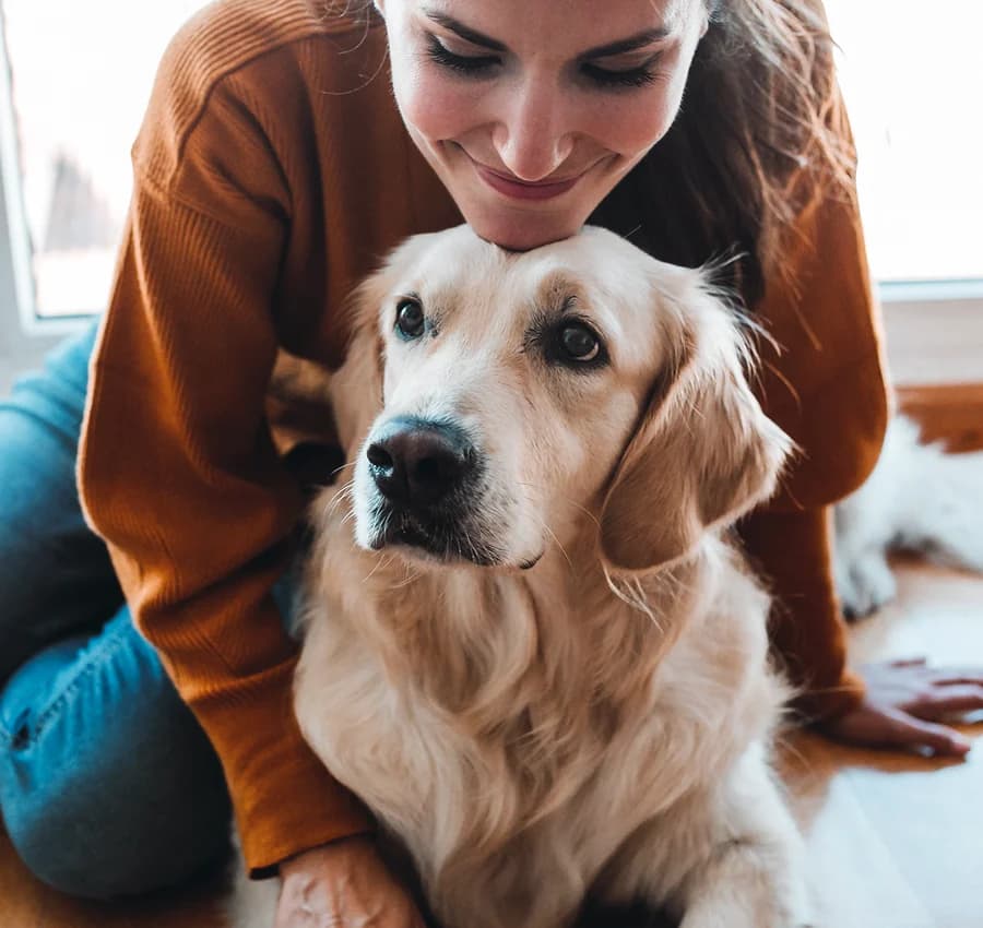Woman hugging a golden dog outdoors